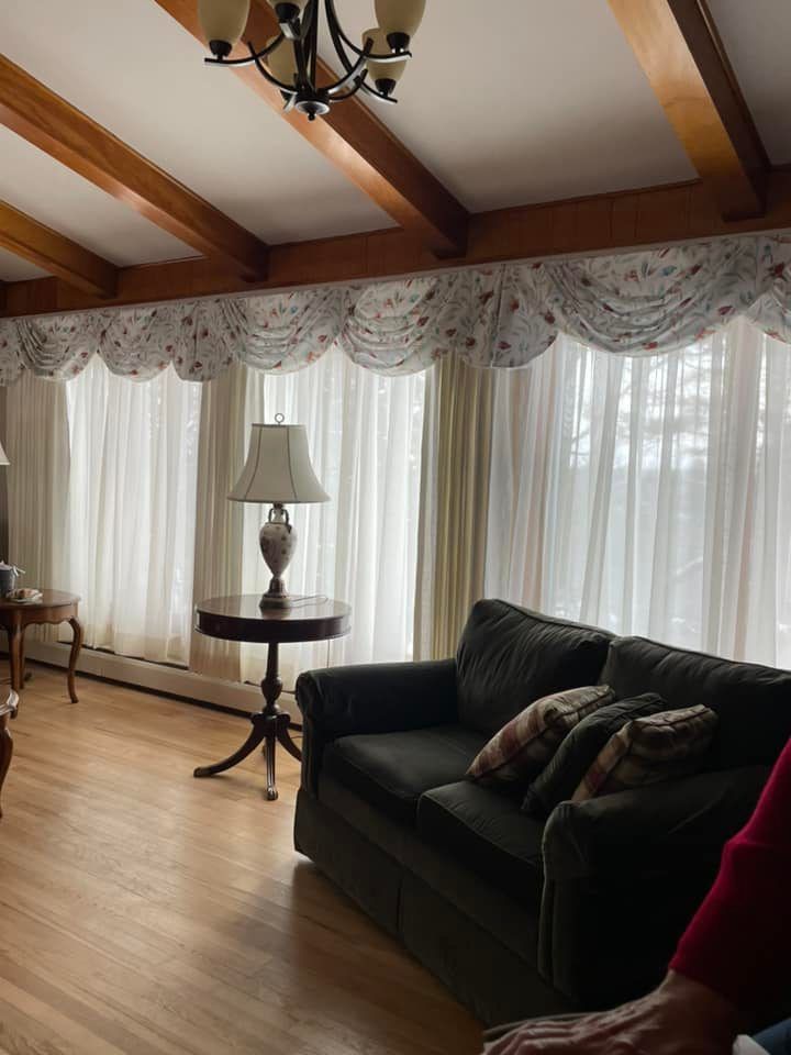A living room with a couch , table and lamp