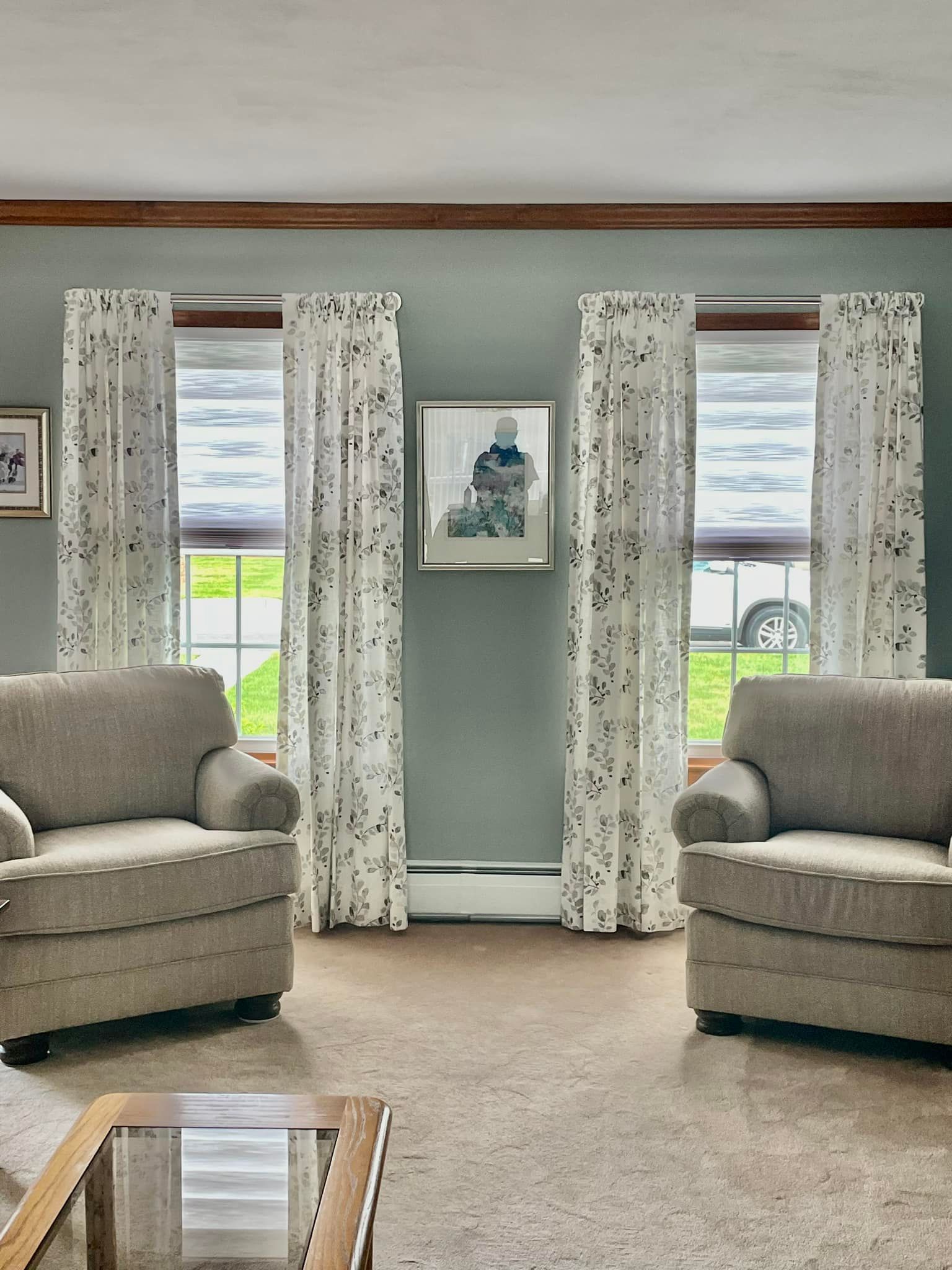 A living room with a couch , chairs , and a large window.
