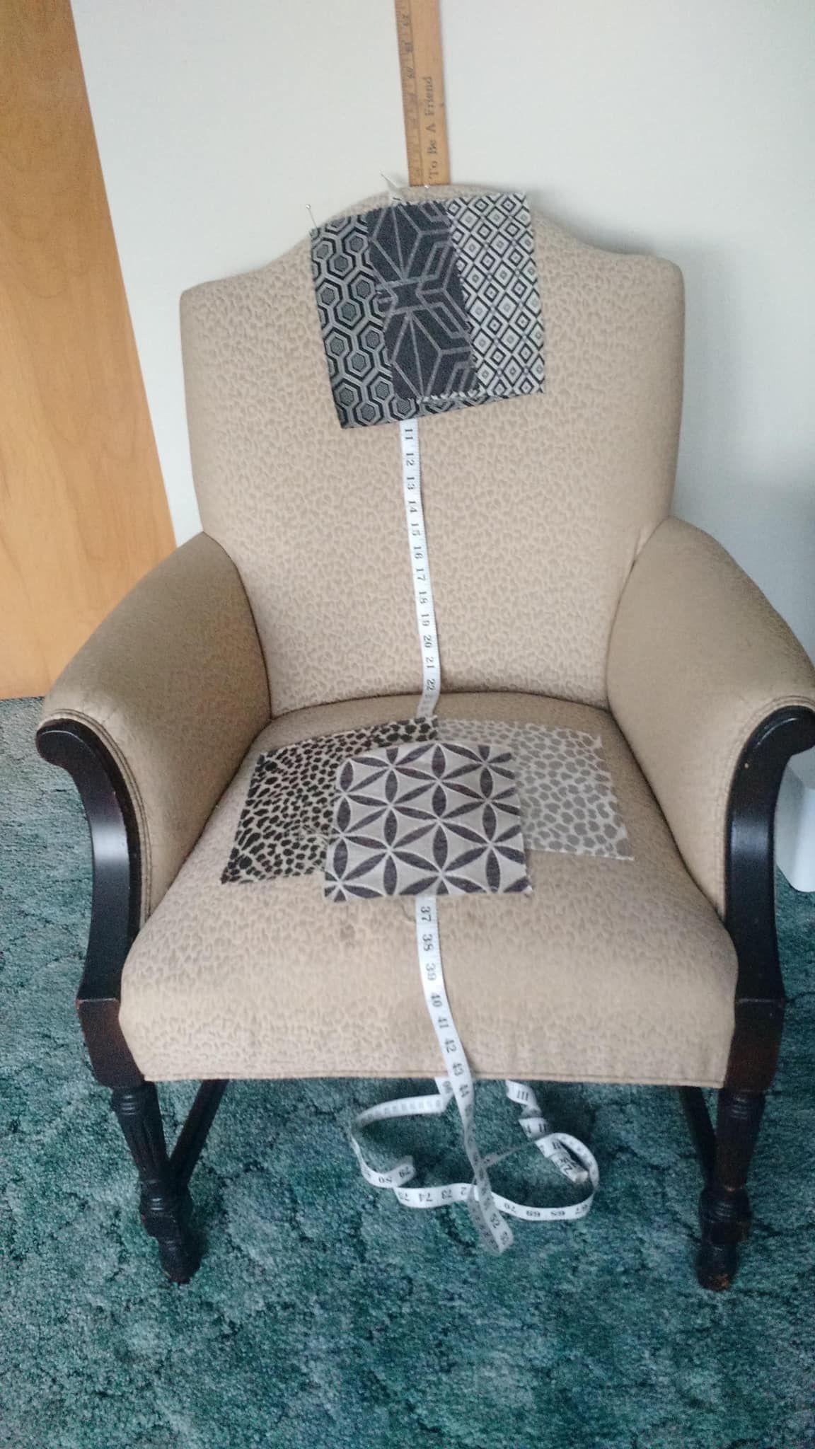 A chair with a measuring tape attached to it is sitting on a green carpet.