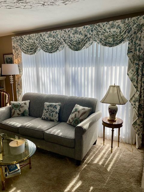 A living room with two chairs and a table in front of a window.