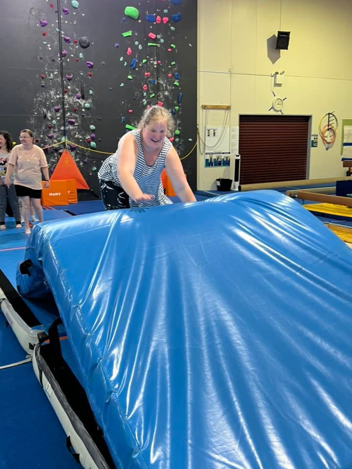 A Woman Standing Over a Blue Tarp in a Gym | Ballarat, Vic | West End Support Services