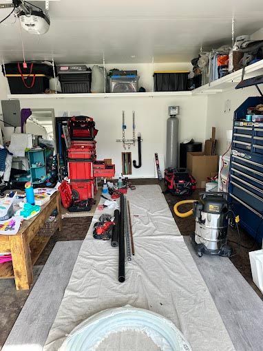 A garage filled with lots of tools and a vacuum cleaner.
