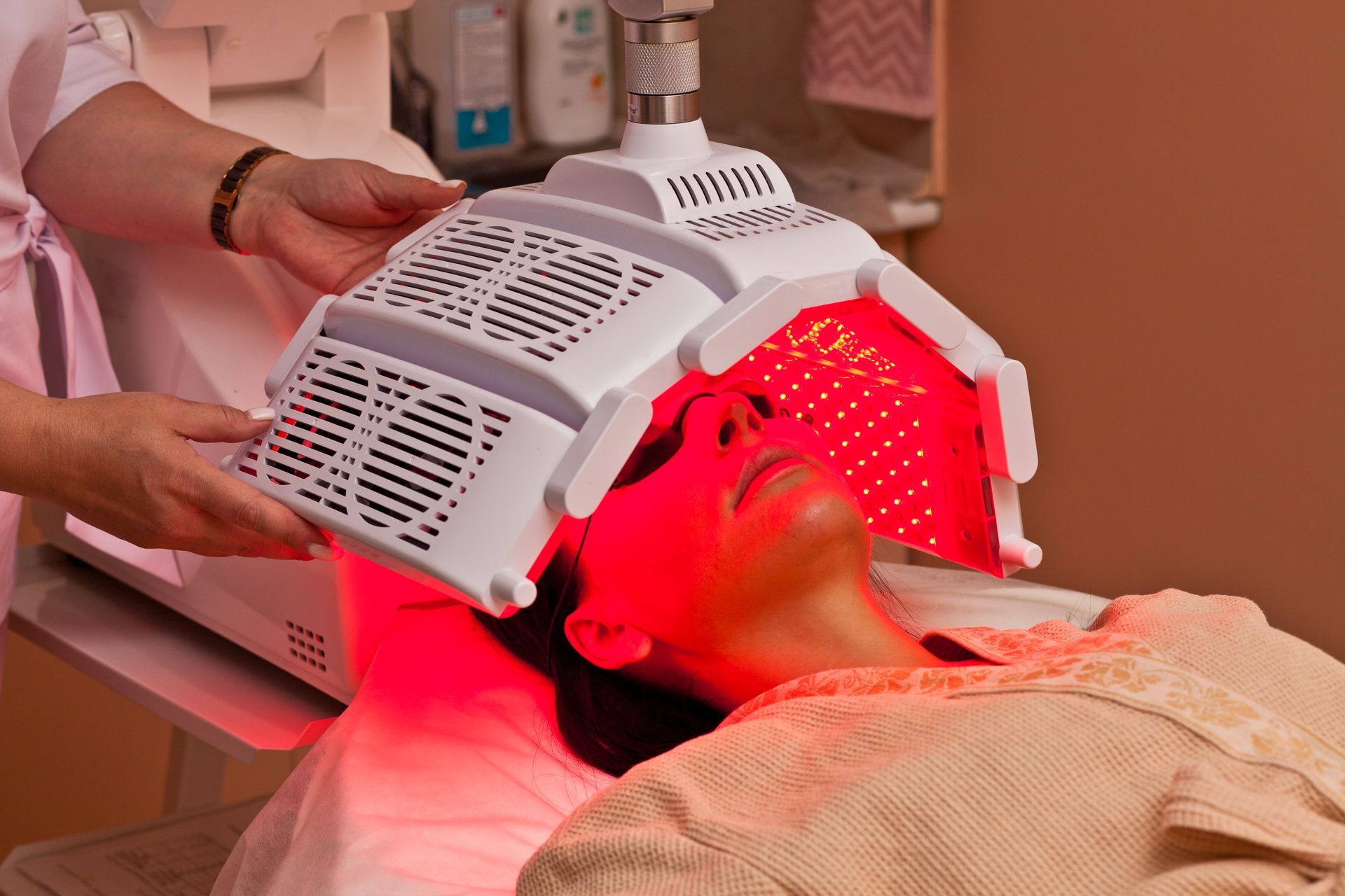 Woman receiving red light therapy treatment at a spa.