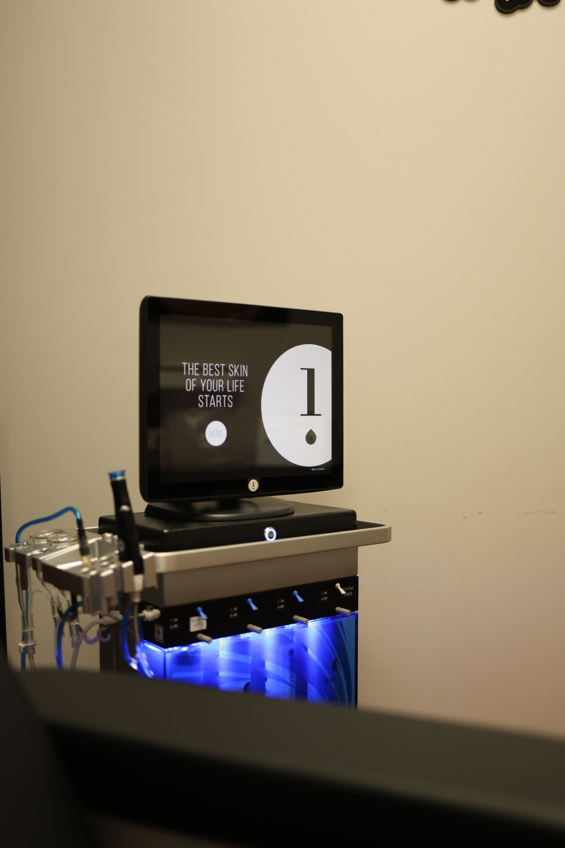 Computer screen showing a large number 1, mounted on a medical cart with blue lighting.