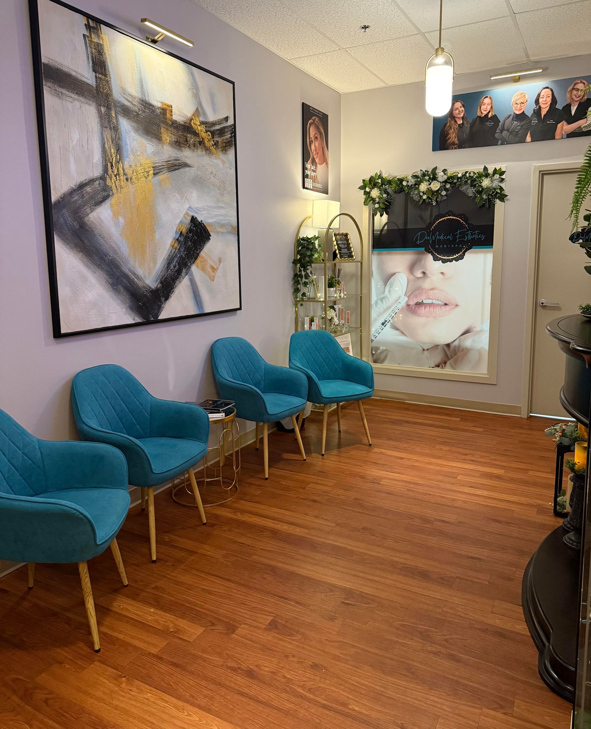 Waiting room with turquoise chairs, abstract art, and a baby photo on the wall.