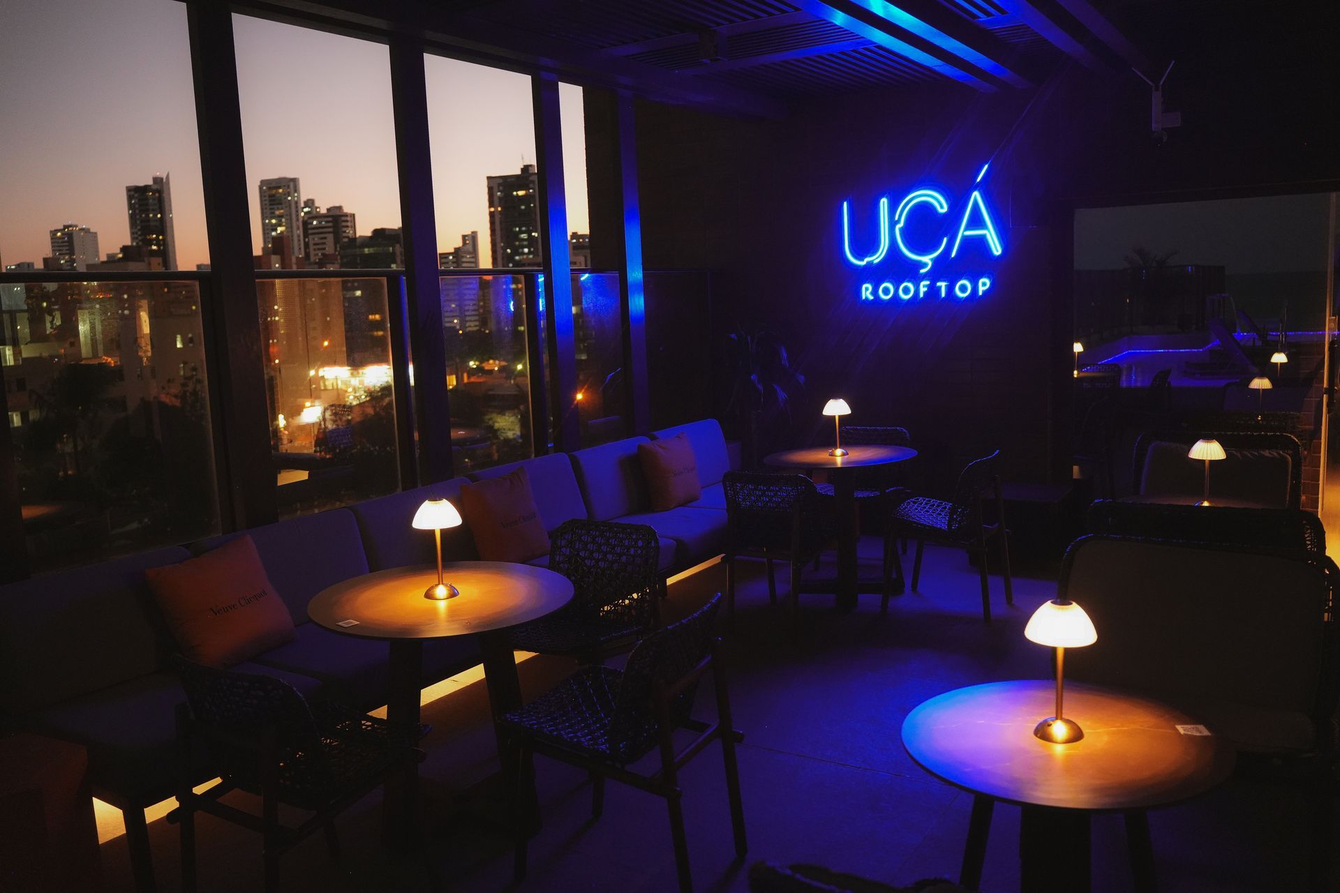 Um quarto escuro com uma placa de neon que diz uca rooftop