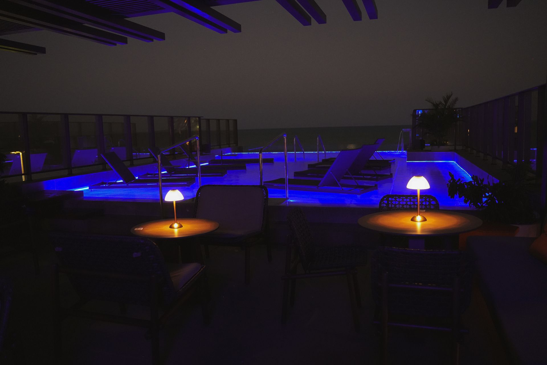 Uma piscina é iluminada com luzes azuis à noite