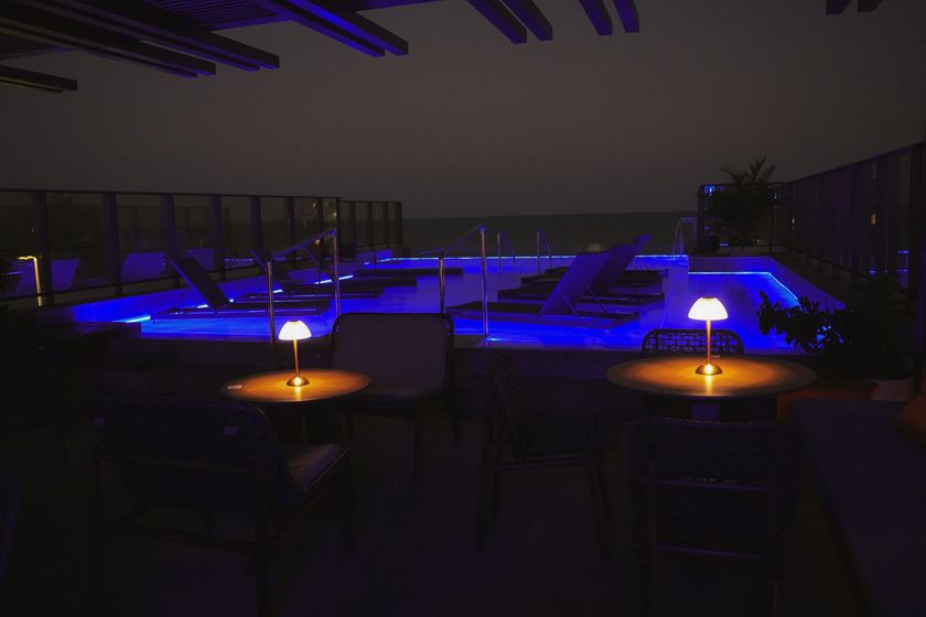 Uma piscina é iluminada com luzes azuis à noite
