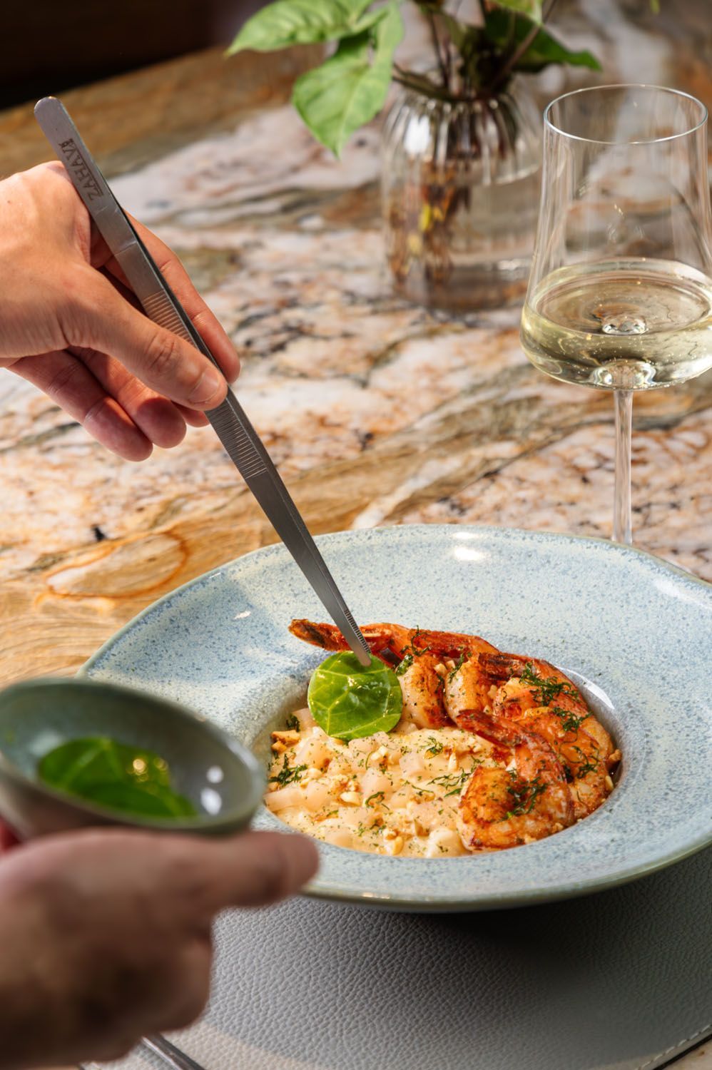 Uma pessoa está servindo um prato de comida com camarão e arroz.