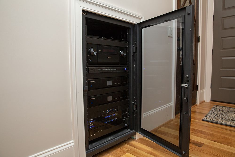 A safe with a glass door is sitting on a wooden floor in a room.