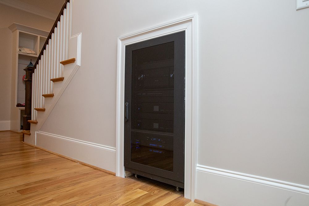 A wine cellar is built into the wall next to a staircase.