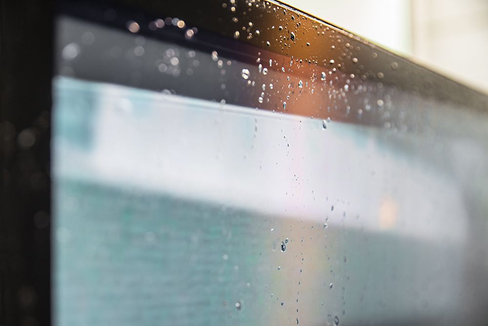 A close up of a computer screen with water drops on it.