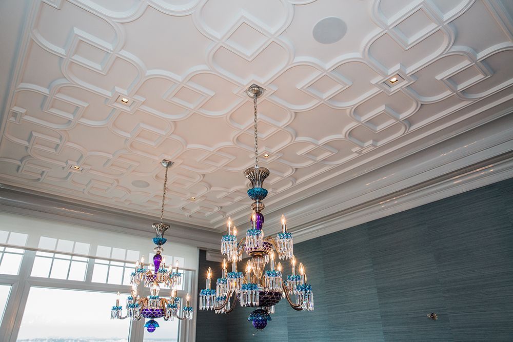 Two chandeliers are hanging from the ceiling of a room.