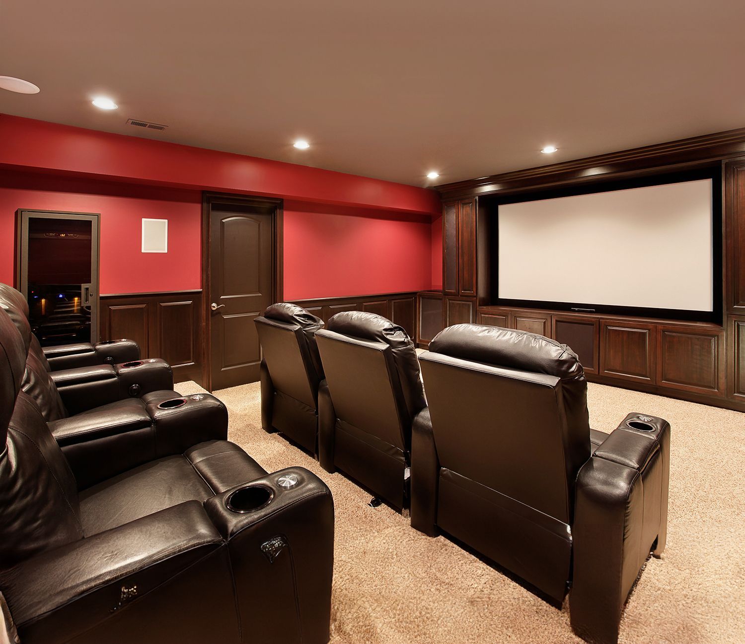 A home theater with leather chairs and a large screen.