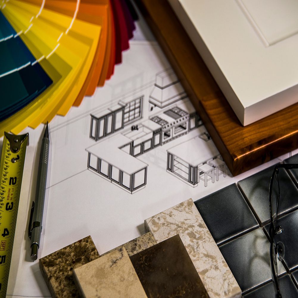 A drawing of a kitchen sits on a table next to a measuring tape