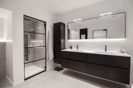 Moderne badkamer met zwarte accenten, een glazen douche en een wastafel met dubbele wastafel.