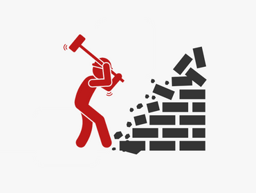 Een man breekt een bakstenen muur met een hamer.