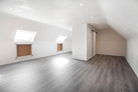 Moderne wachtkamer met bruine stoelen, kleine tafeltjes en kamerhoge ramen met uitzicht op het groen.