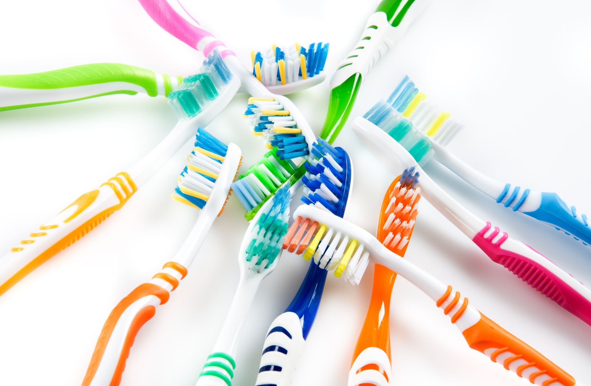 A bunch of colorful toothbrushes on a white surface