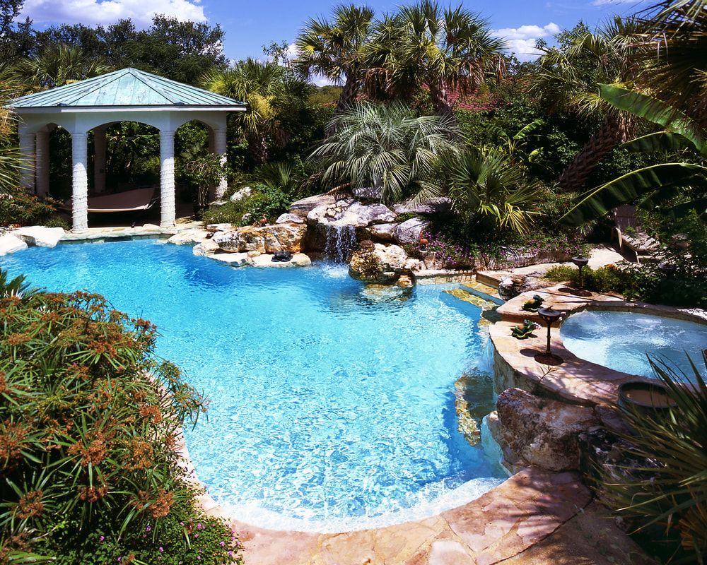 A large swimming pool with a gazebo in the background
