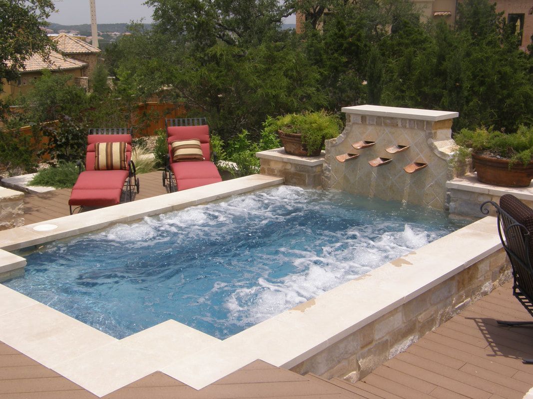 A large swimming pool with a waterfall in the backyard