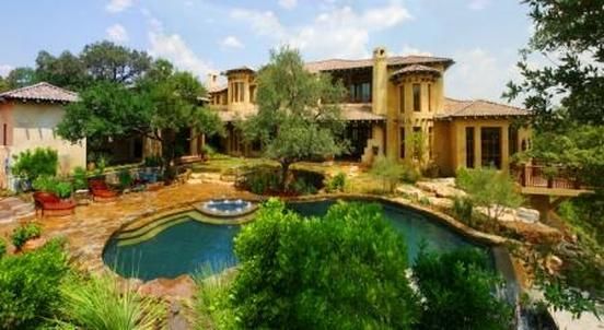 A large house with a swimming pool in front of it