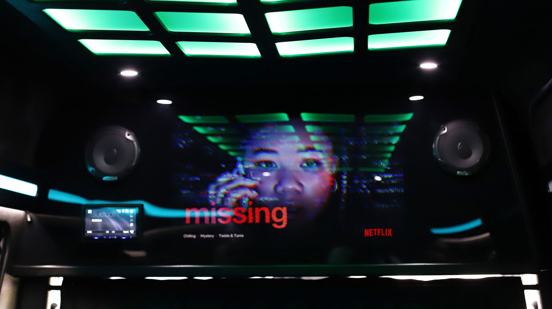 Interior view of a vehicle, a person on a large screen watches