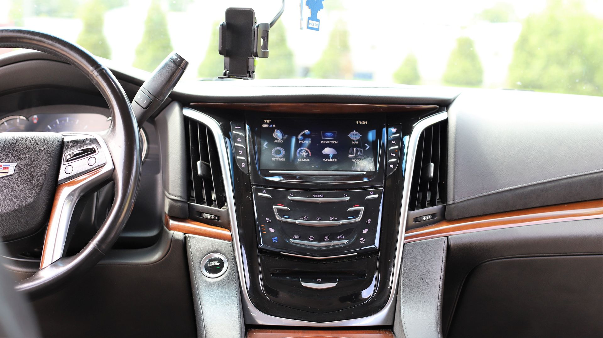 Dashboard of a Cadillac Escalade SUV, with steering wheel on the left and center console with infotainment screen.