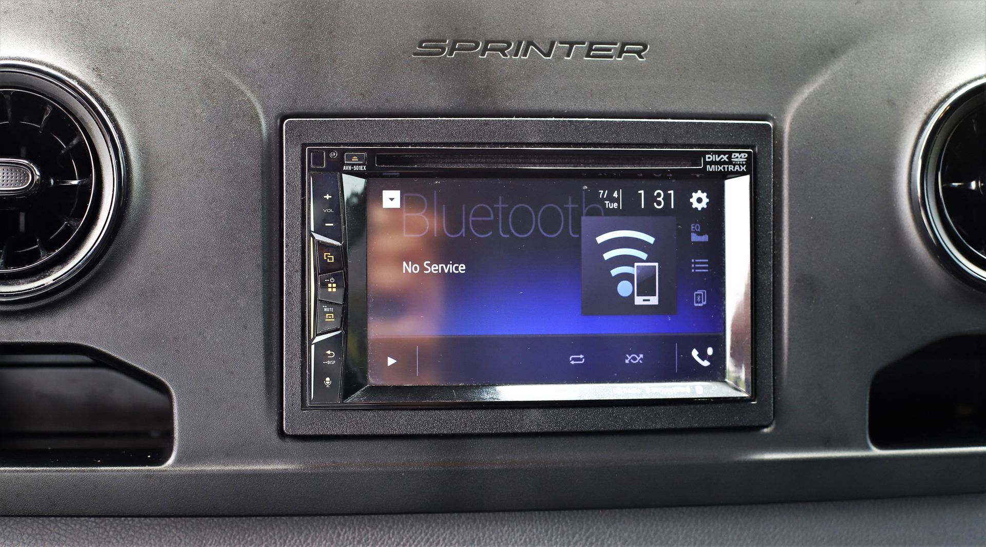 A Sprinter van's dashboard featuring an aftermarket car stereo displaying a Bluetooth connection screen.