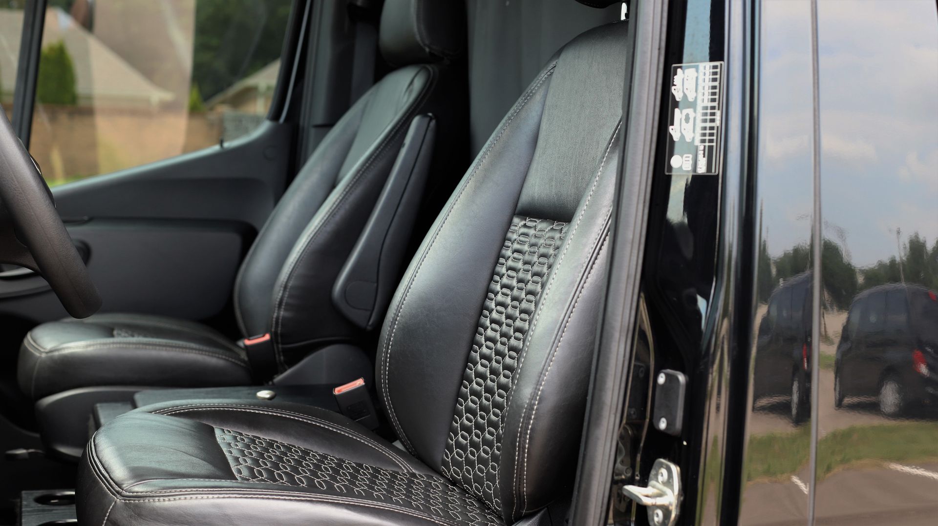 Black leather van seats with textured center panels.