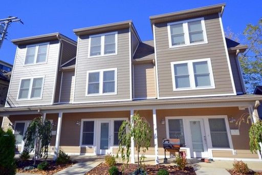 A large apartment building with a barbecue grill in front of it.