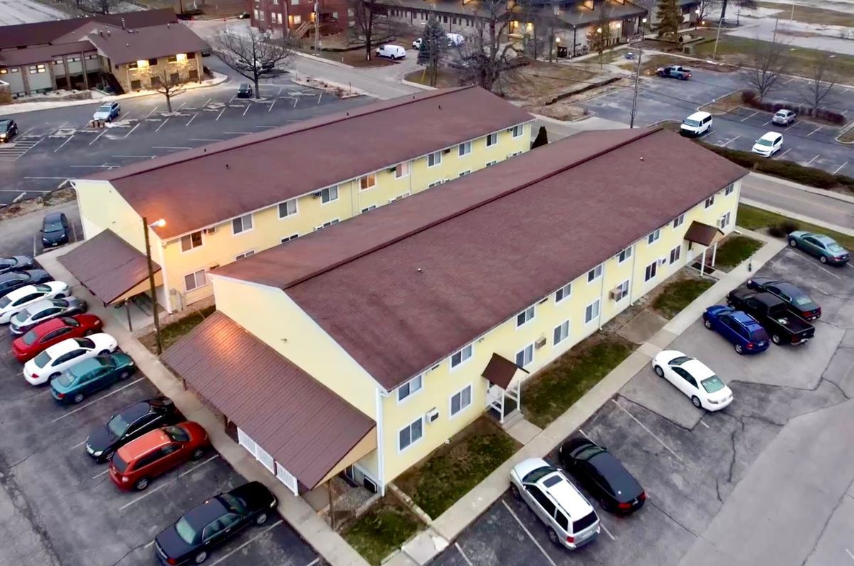 An aerial view of a building with cars parked in front of it.