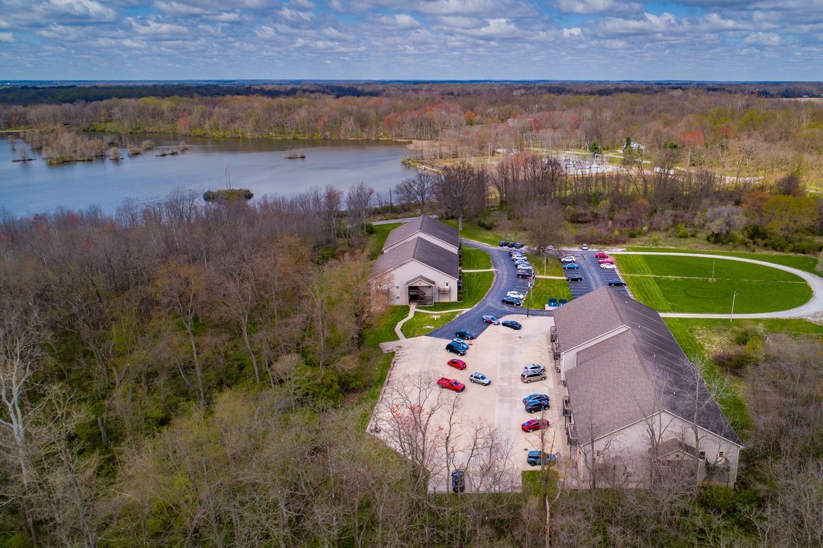 An aerial view of a park with a lake in the background.