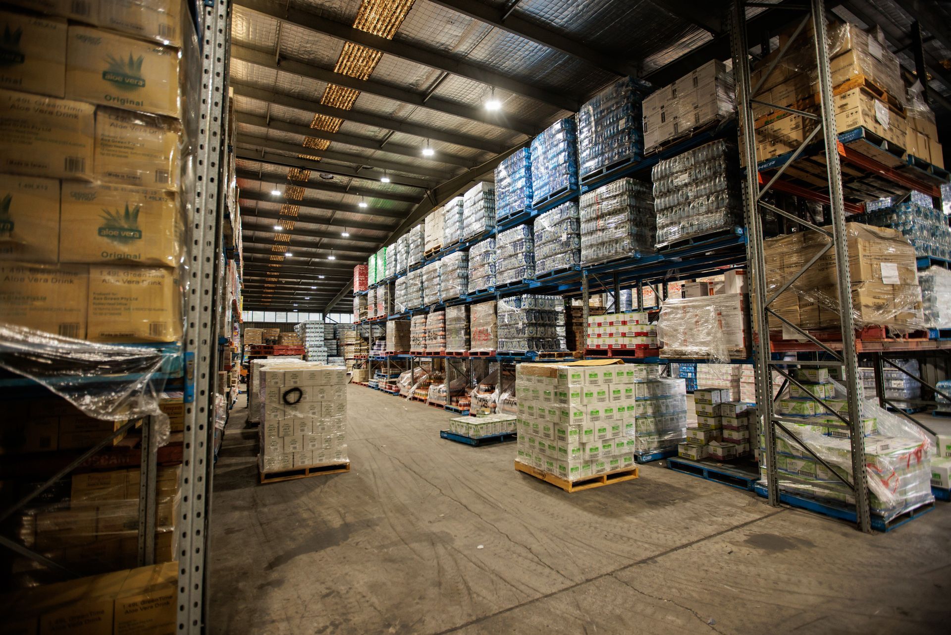 A large warehouse filled with lots of boxes and pallets.