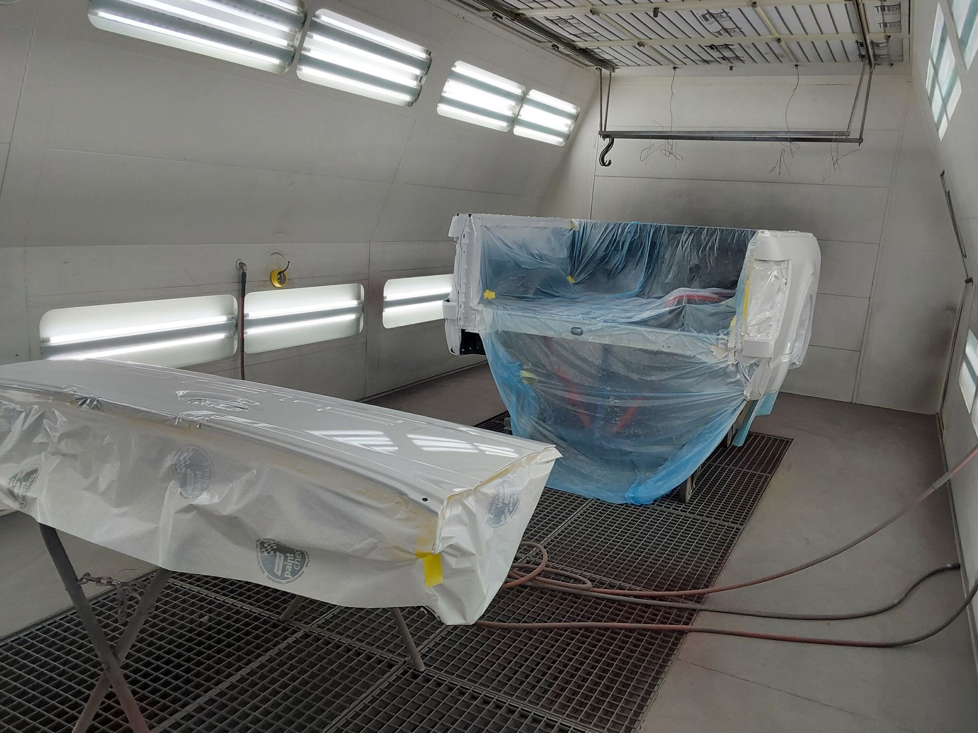 A boat is being painted in a paint booth.