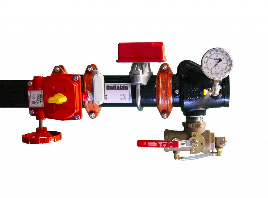 A close up of a fire sprinkler system with a red valve and a pressure gauge.
