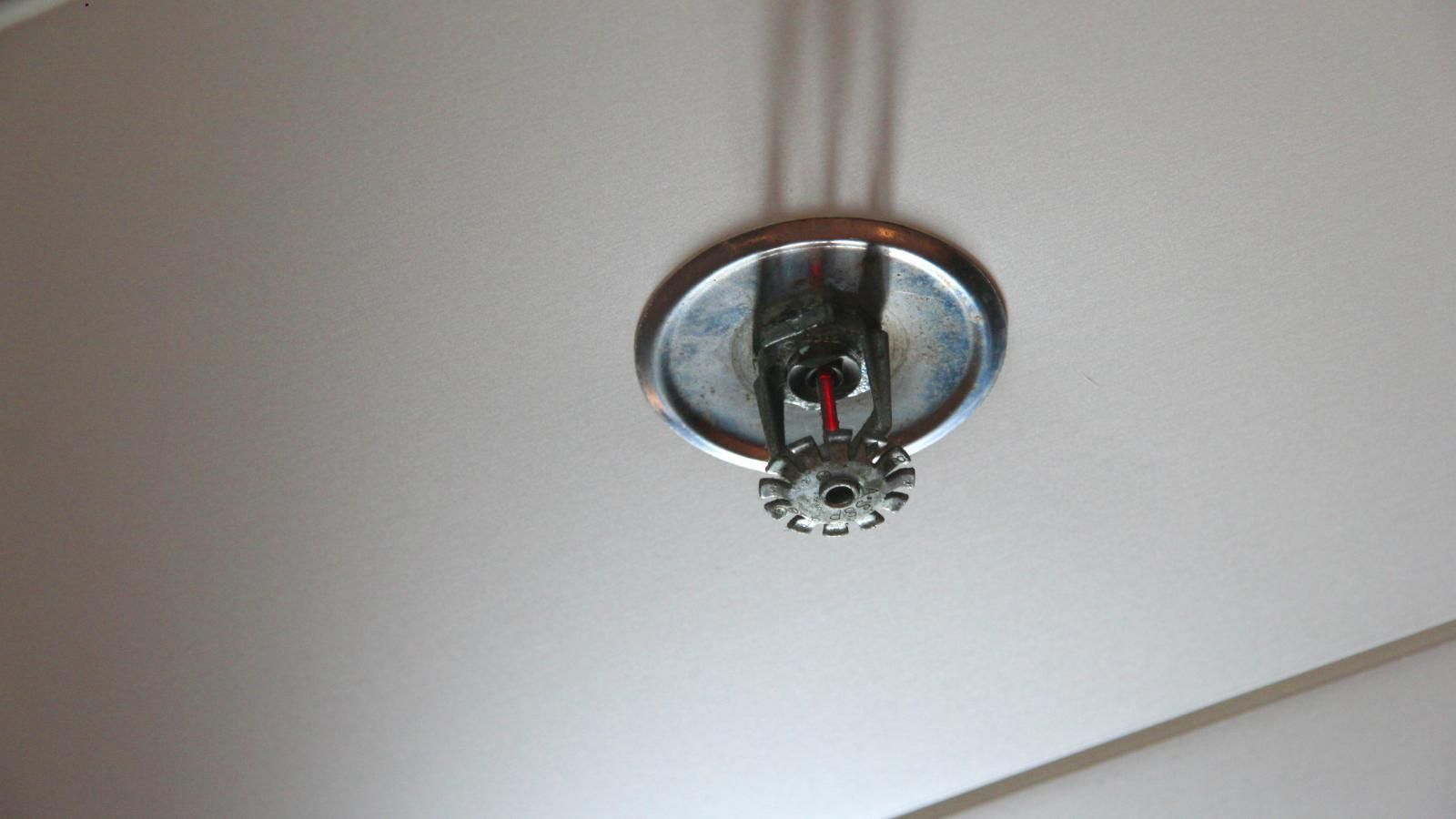 A fire sprinkler is hanging from the ceiling of a room.