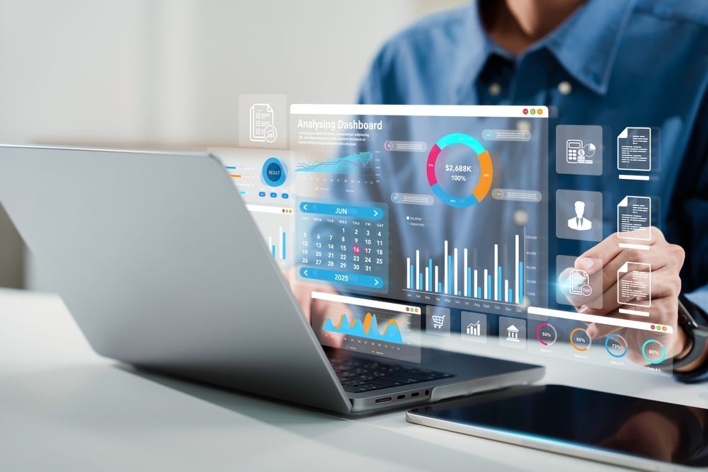 Person analyzing data on a laptop with virtual charts and graphs overlaid.