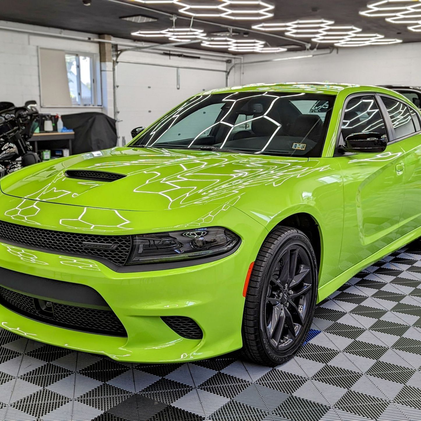 a green dodge charger is parked in a garage. Ceramic coating ppf johnstown pa