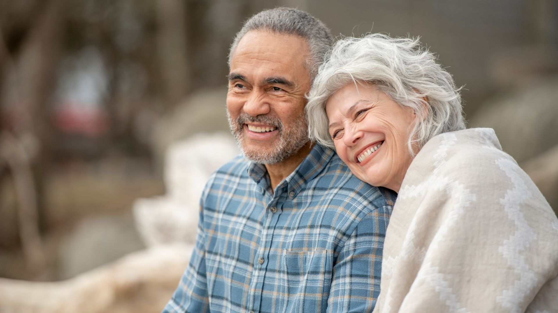 A man and a woman are sitting next to each other and smiling.