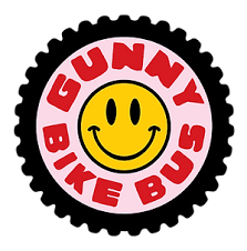 Gunny Bike Bus logo: Smiley face inside pink circle with red text on a black gear outline.
