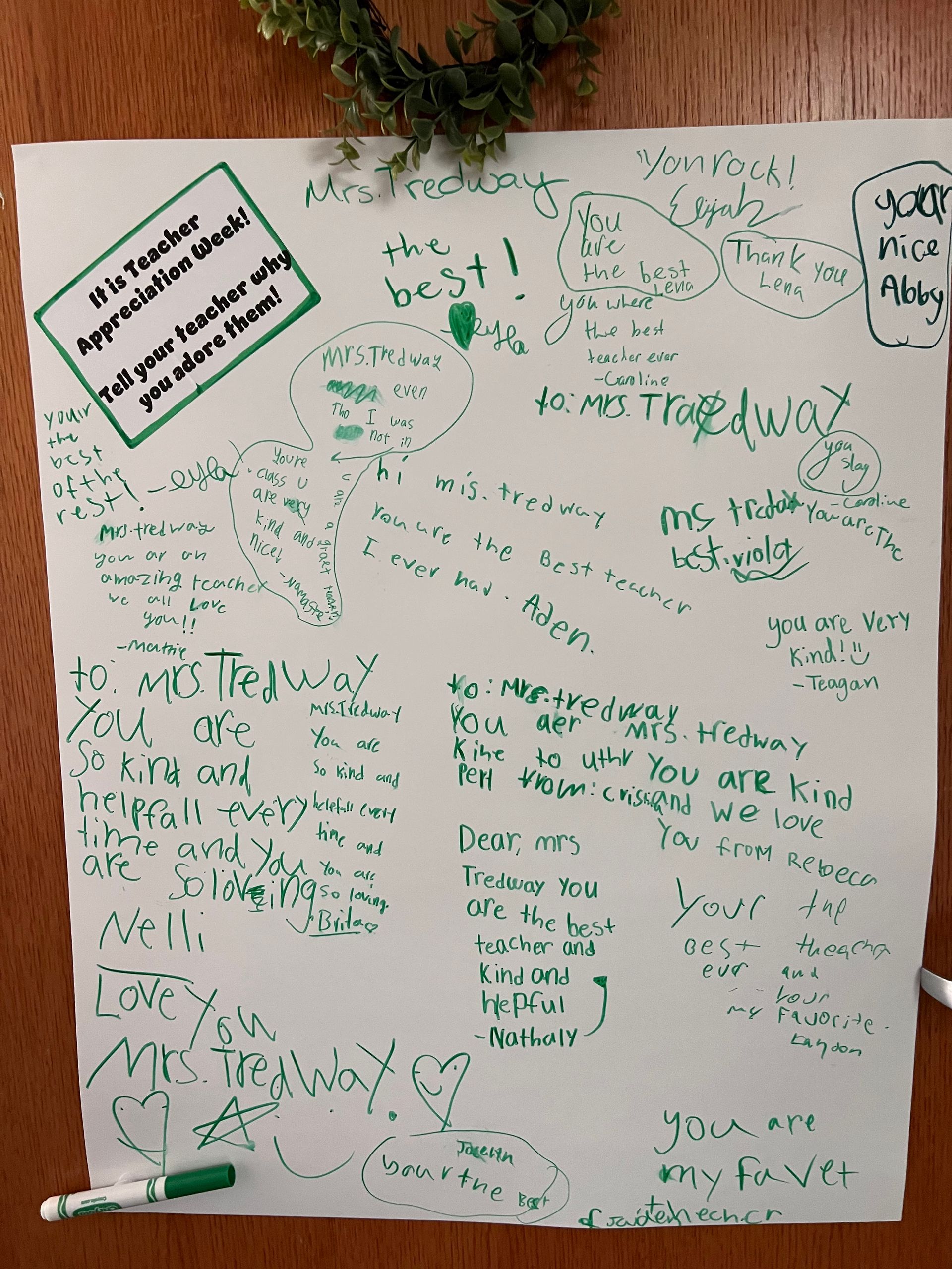 A white board with a green marker and a wreath on it