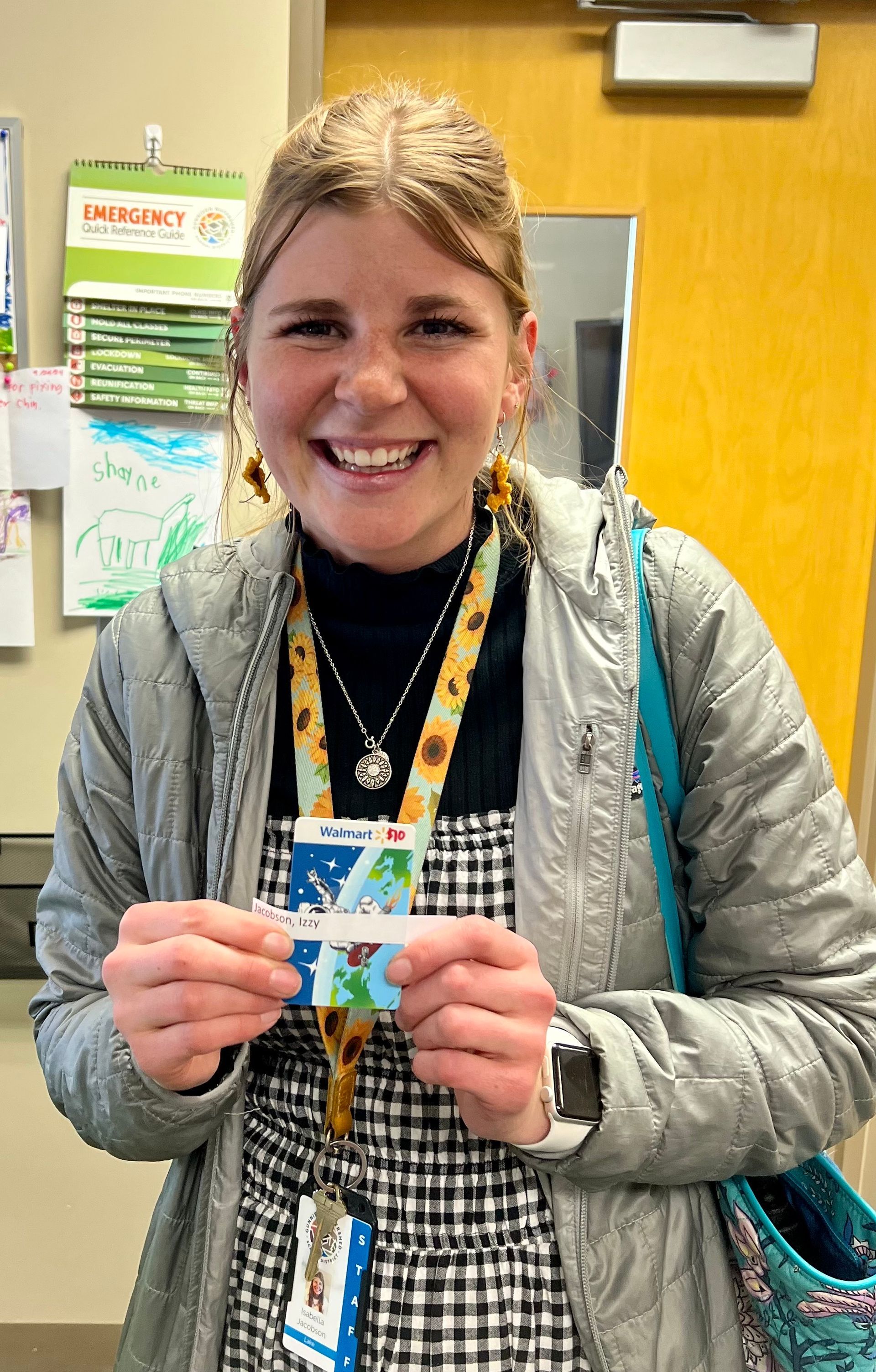 A woman is holding a piece of paper in her hands and smiling.