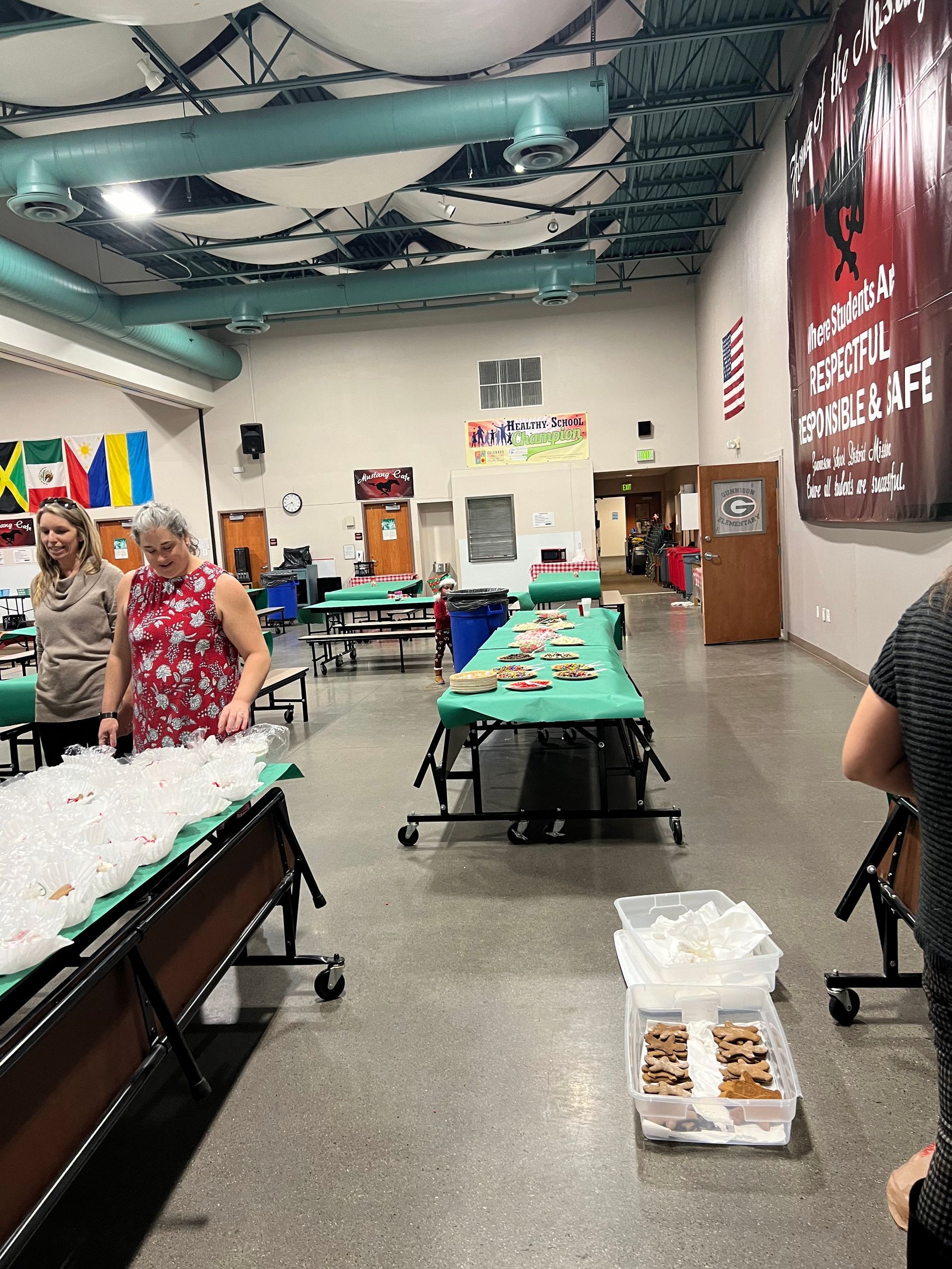 A group of people are standing around tables in a large room.