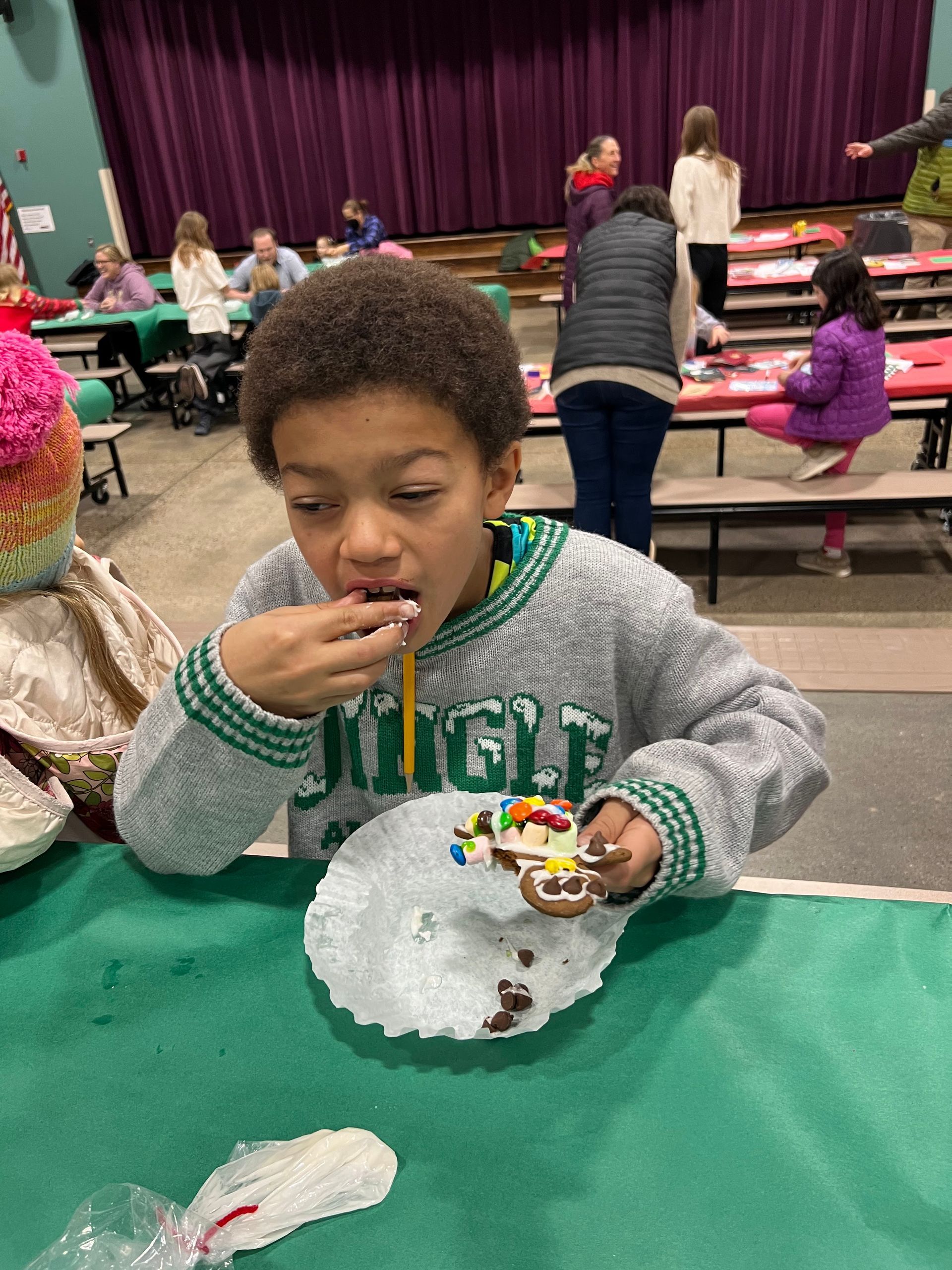 A young boy is sitting at a table eating a piece of cake.