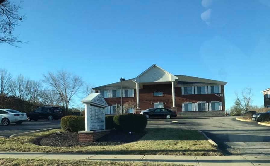 A large brick building with cars parked in front of it.