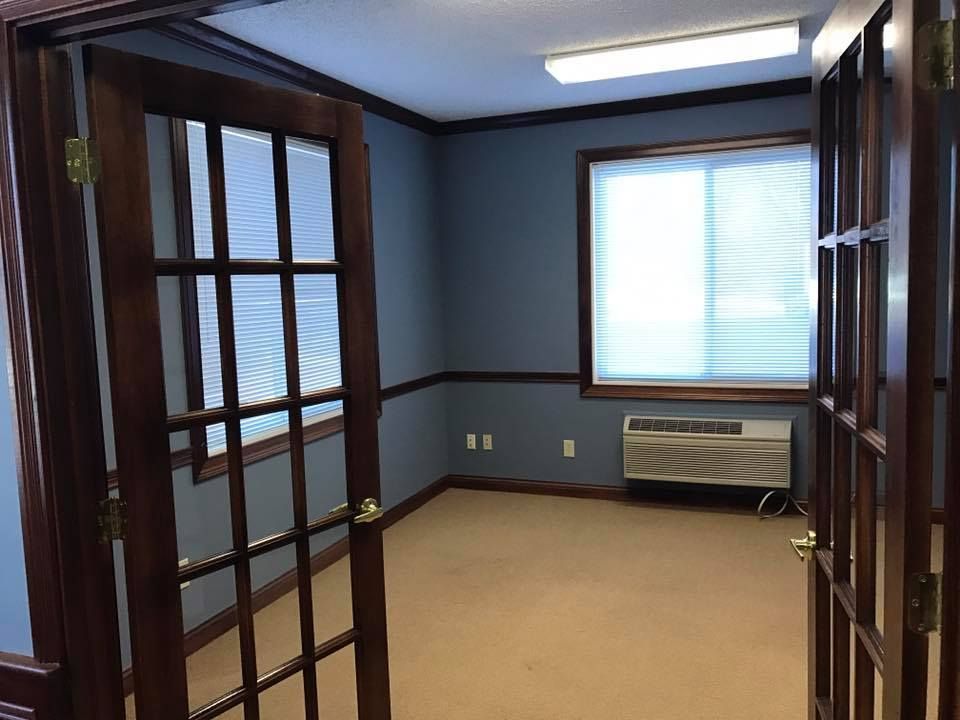 An empty room with french doors and a window