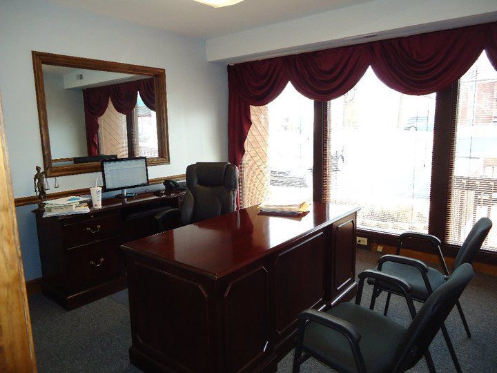 A room with a desk and chairs and a large mirror