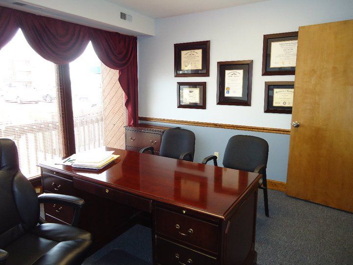A room with a desk and chairs and a window