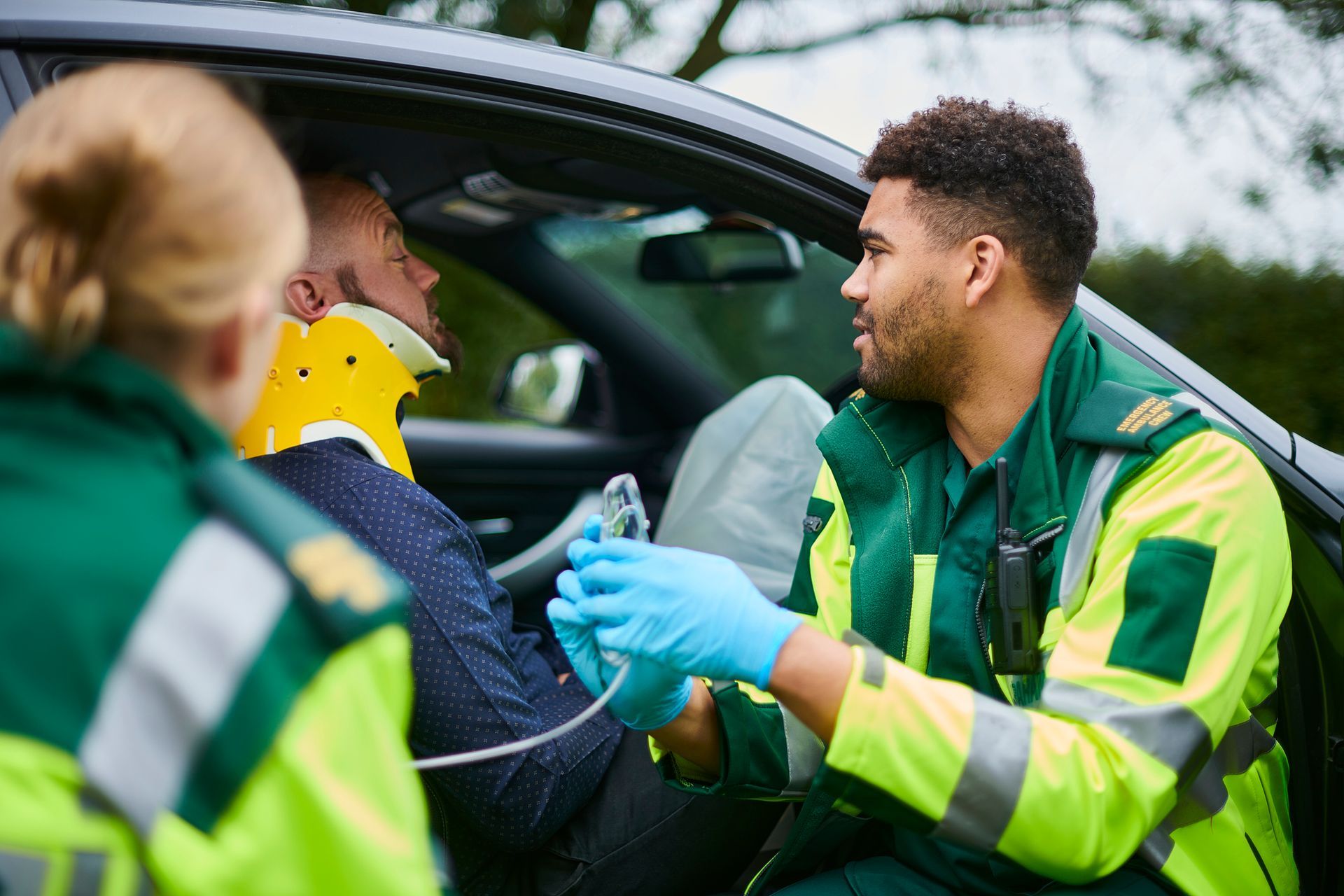 Paramedics administering oxygen at car crash